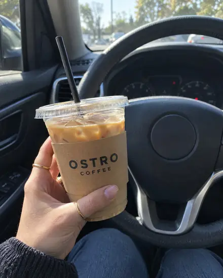 Phone shot of an iced latte held in a parked car